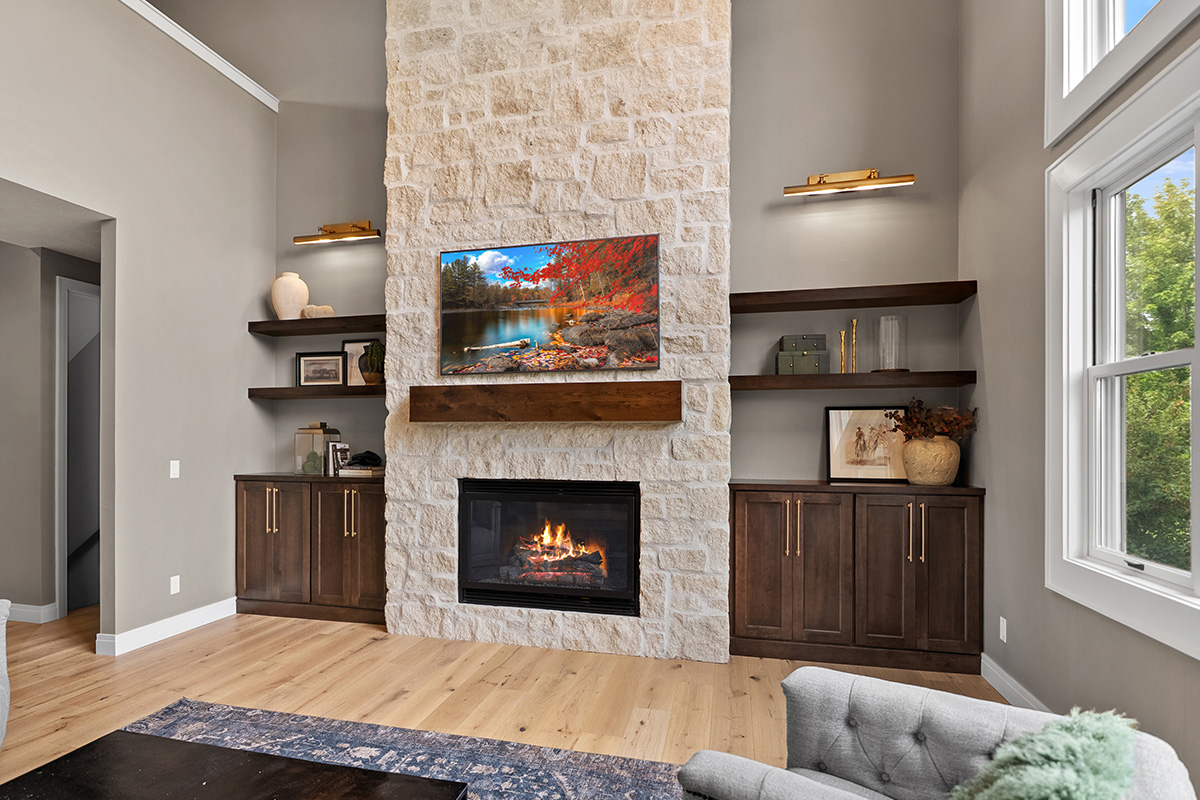 Fireplace with dark stained cabinets on each side.