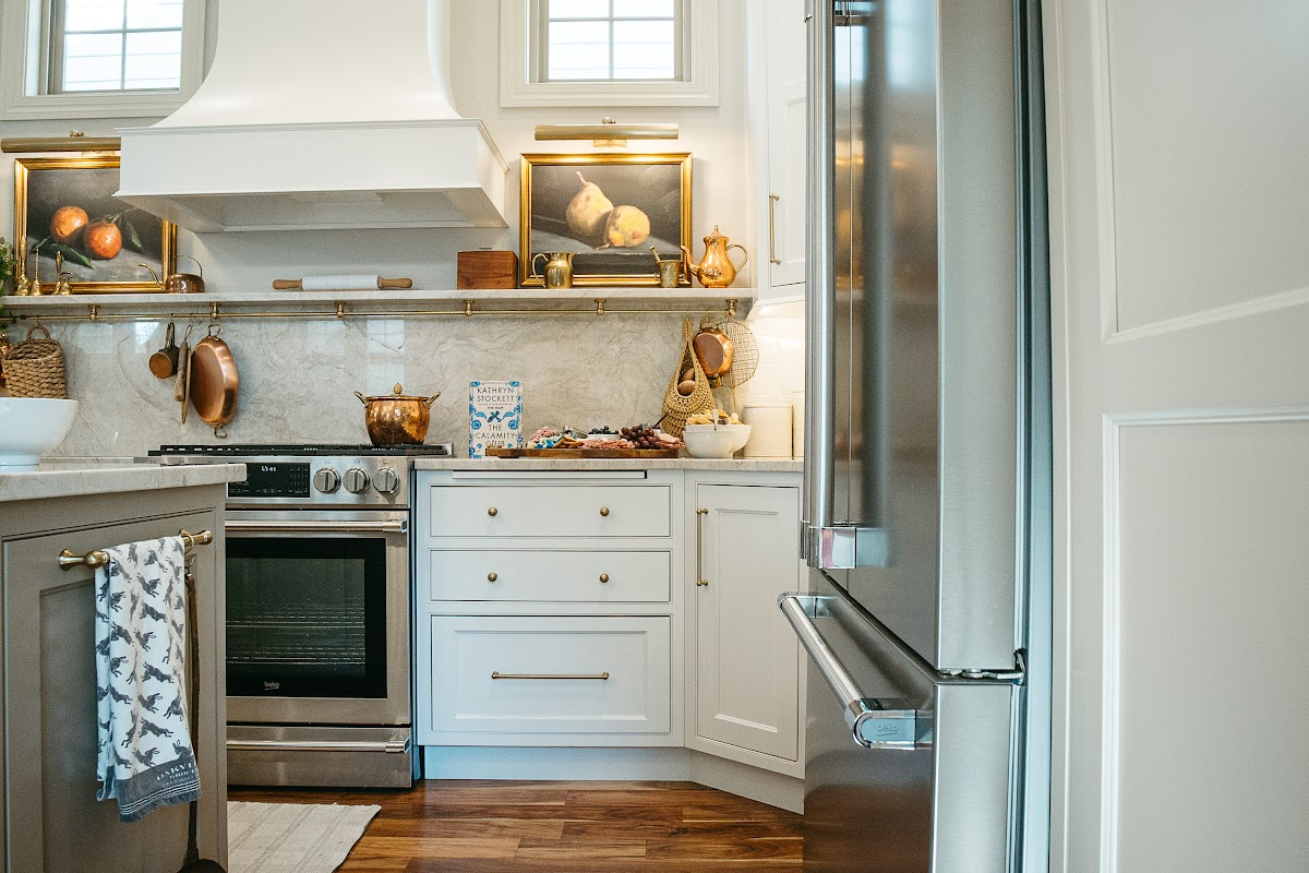 White kitchen perimeter cabinets with brown island.