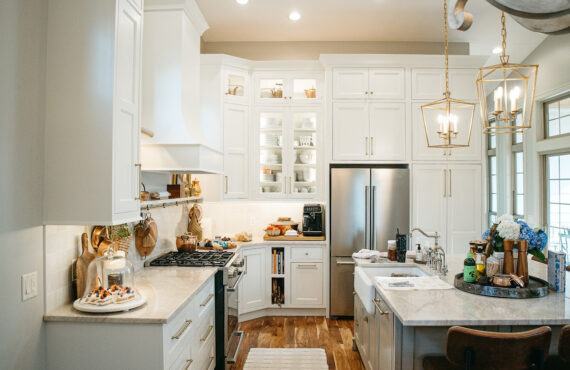 White kitchen perimeter cabinets with brown island.