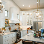 White kitchen perimeter cabinets with brown island.