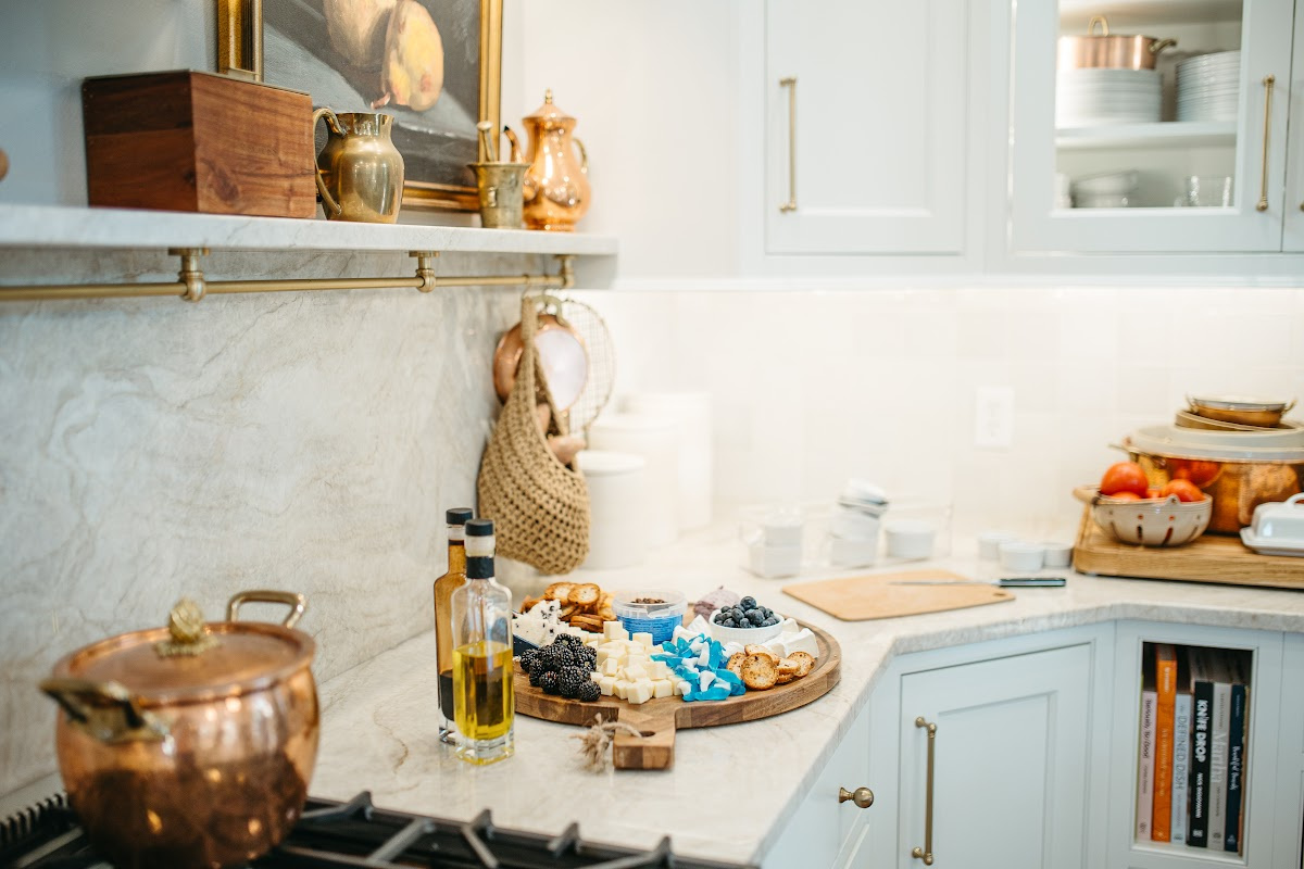 White kitchen cabinets with appetizers on the counter.