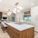 Beige painted kitchen perimeter cabinets with a 16-foot stained quartersawn white oak island wtih seating.