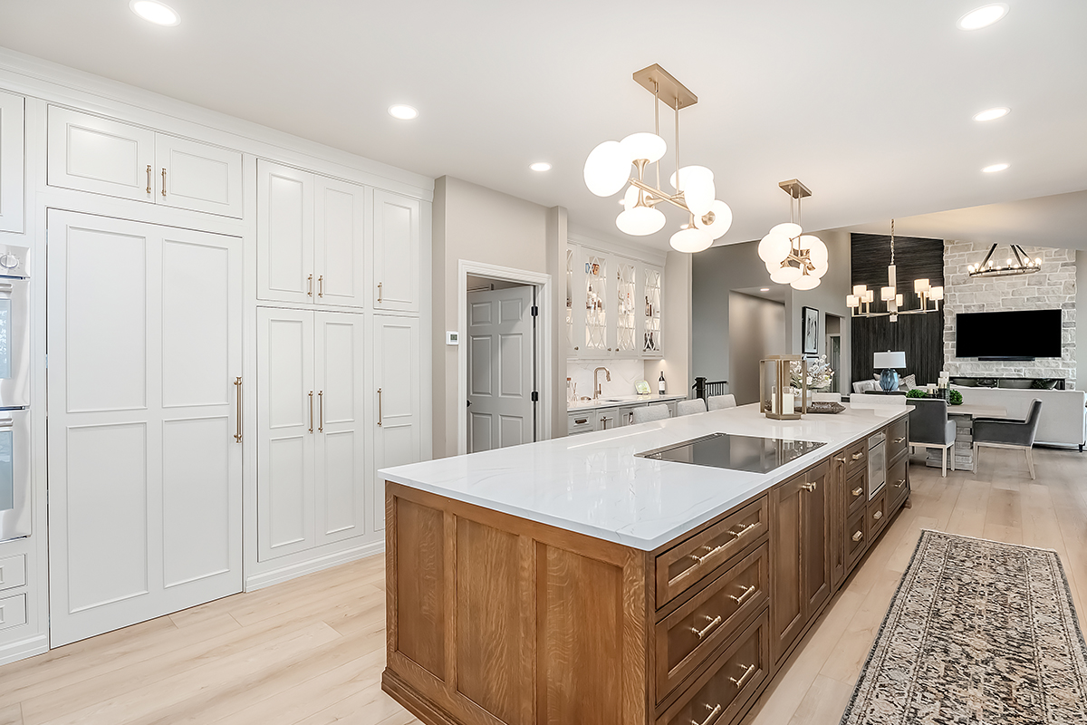Beige painted kitchen perimeter cabinets with a 16-foot stained quartersawn white oak island wtih seating.