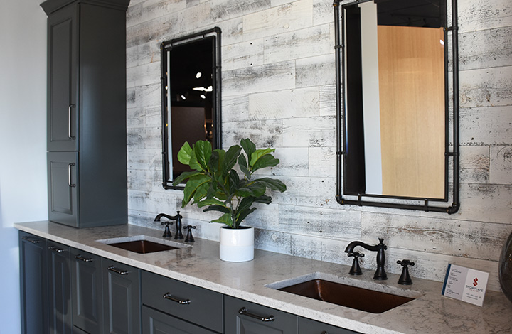 Bathroom remodel. Dual sinks with a white washed wall, heavy rimed mirrors and black cabinets in the Iowa Showplace Design Center Showroom