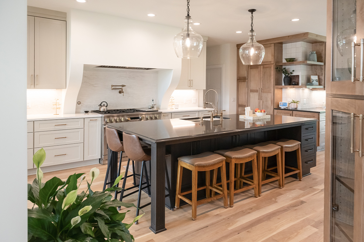 Kitchen with light brown stained and white painted perimeter cabinets and dark stained island.